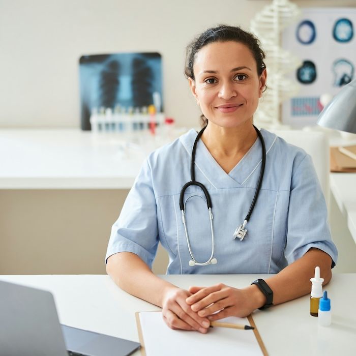 Une infirmière souriant en regardant la caméra